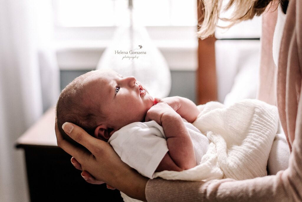 mom looks down at baby girl during Lifestyle Newborn Session in Quincy MA