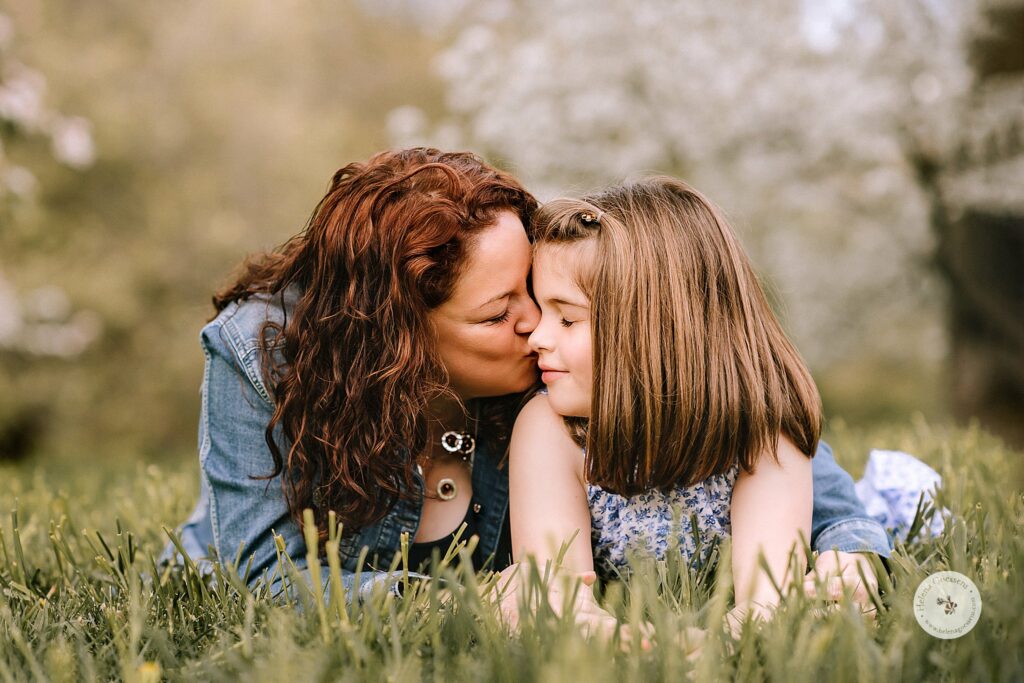 mom gives daughter a kiss during spring family photos in Boston