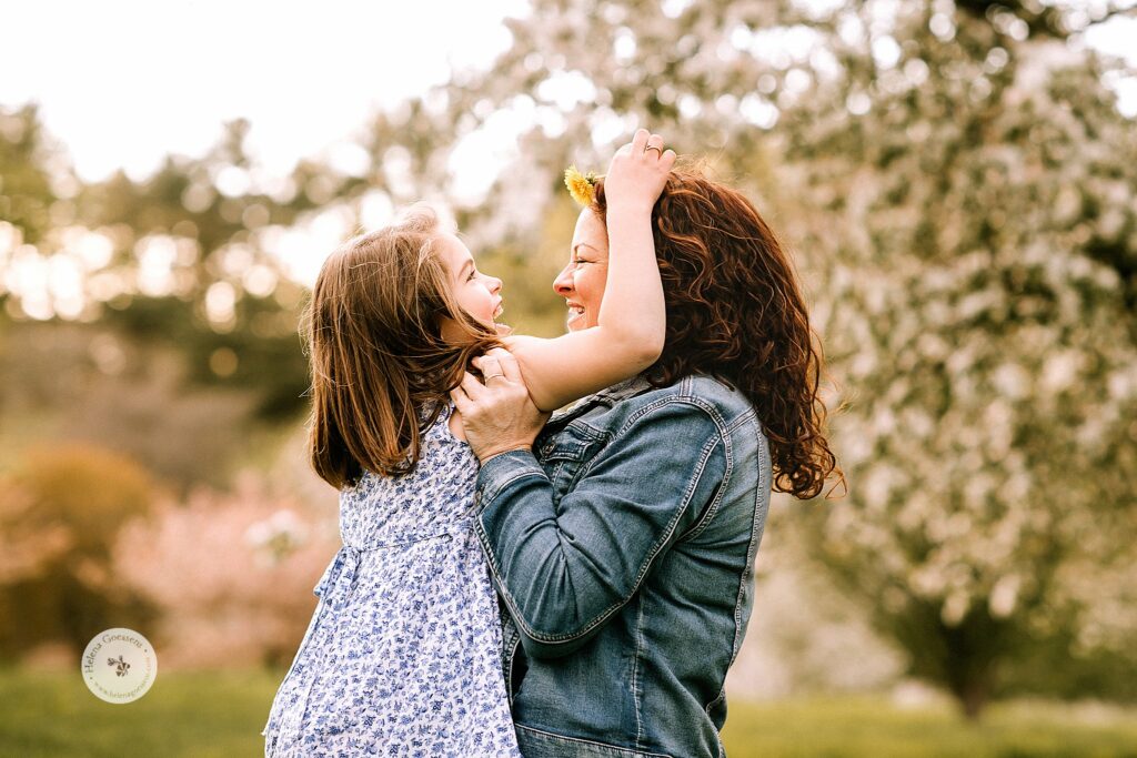 daughter gives mom a flower during spring family photos 