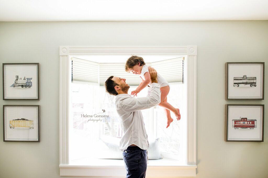 dad lifts son up in room at home in Weston MA 