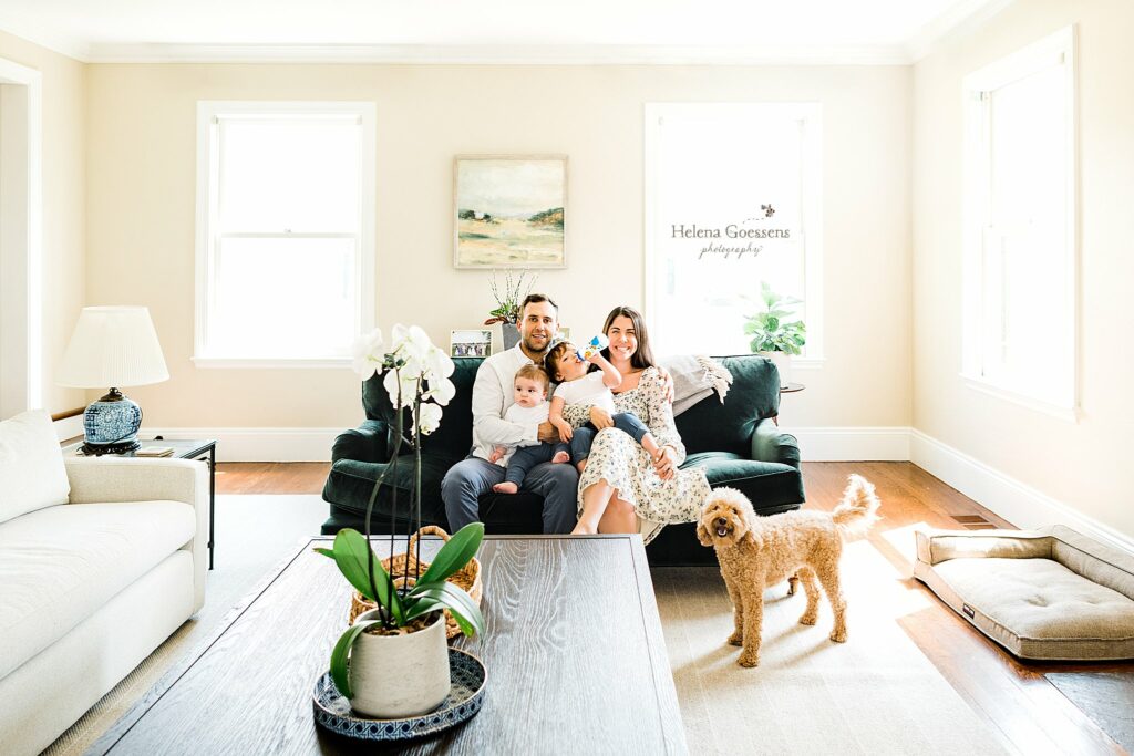 family of four sits on couch during Lifestyle Family Portraits in Weston MA with dog