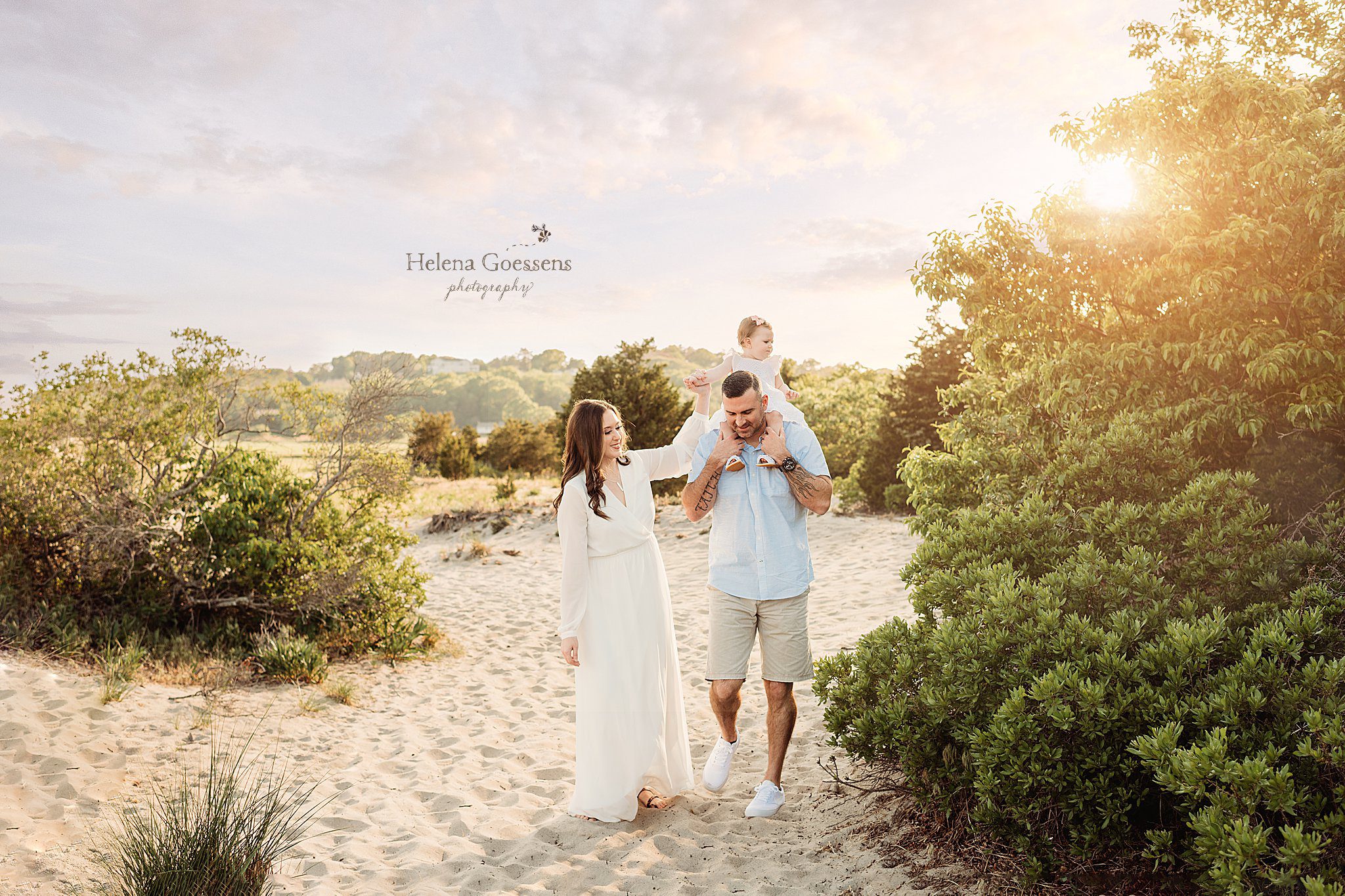 dad walks with toddler daughter on shoulders while mom holds her hand during Rexhame Beach family session
