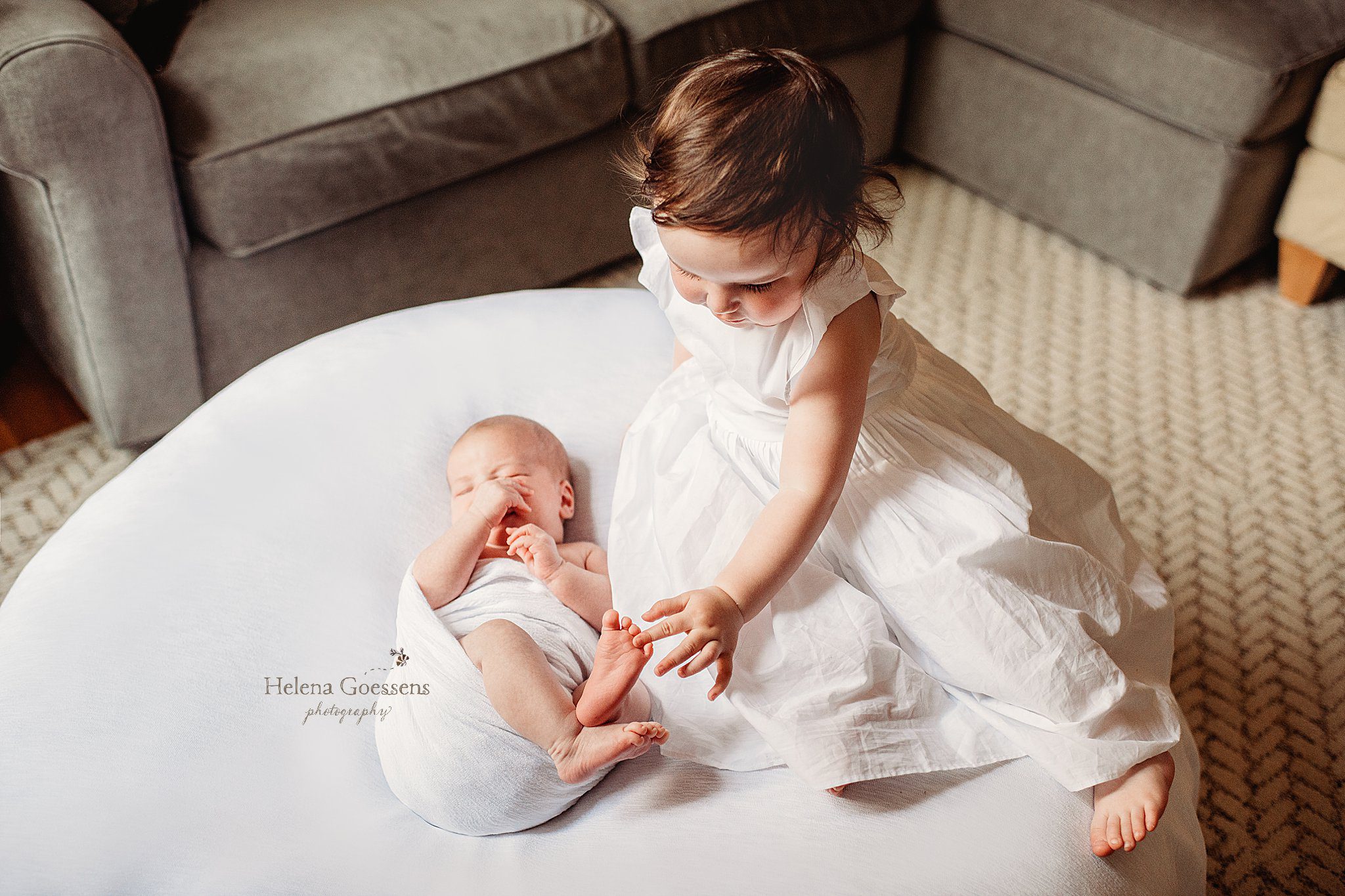 sister plays with baby brother's toes during South End newborn session