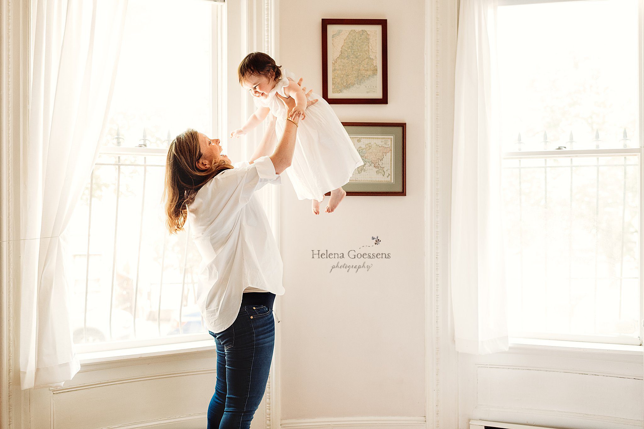 mom lifts toddler up in living room during South End newborn session