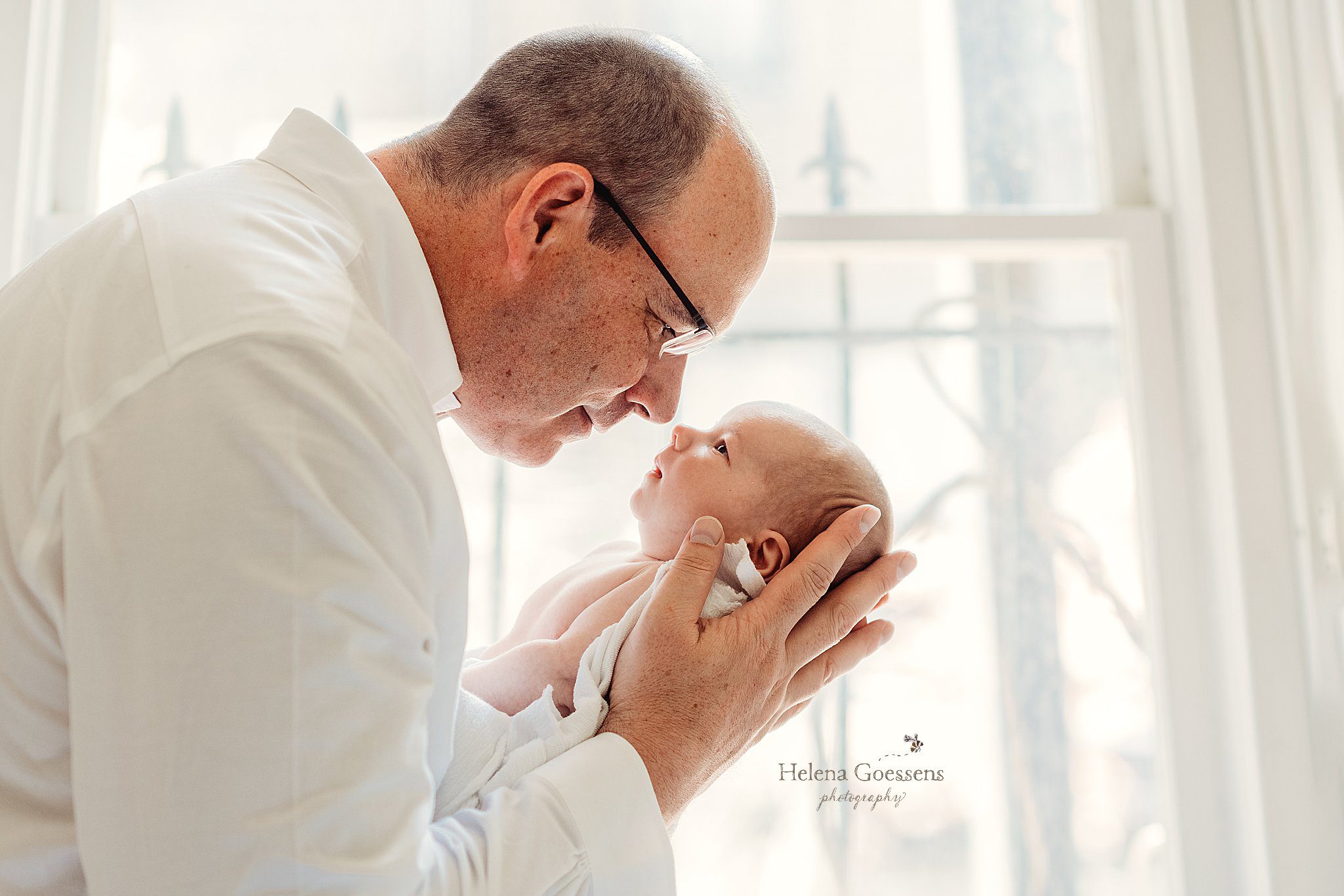 dad touches noses with newborn son during newborn photos at home in Boston MA