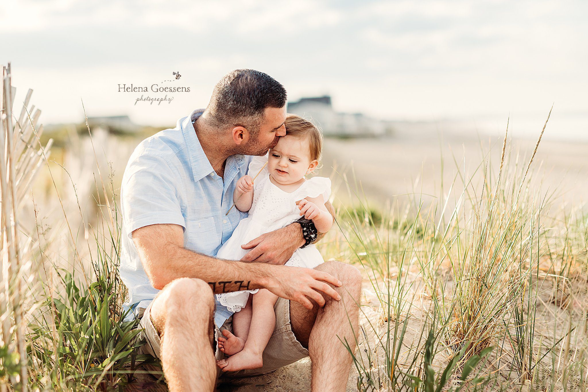 dad sits with daughter in sea grass during MA family portraits 