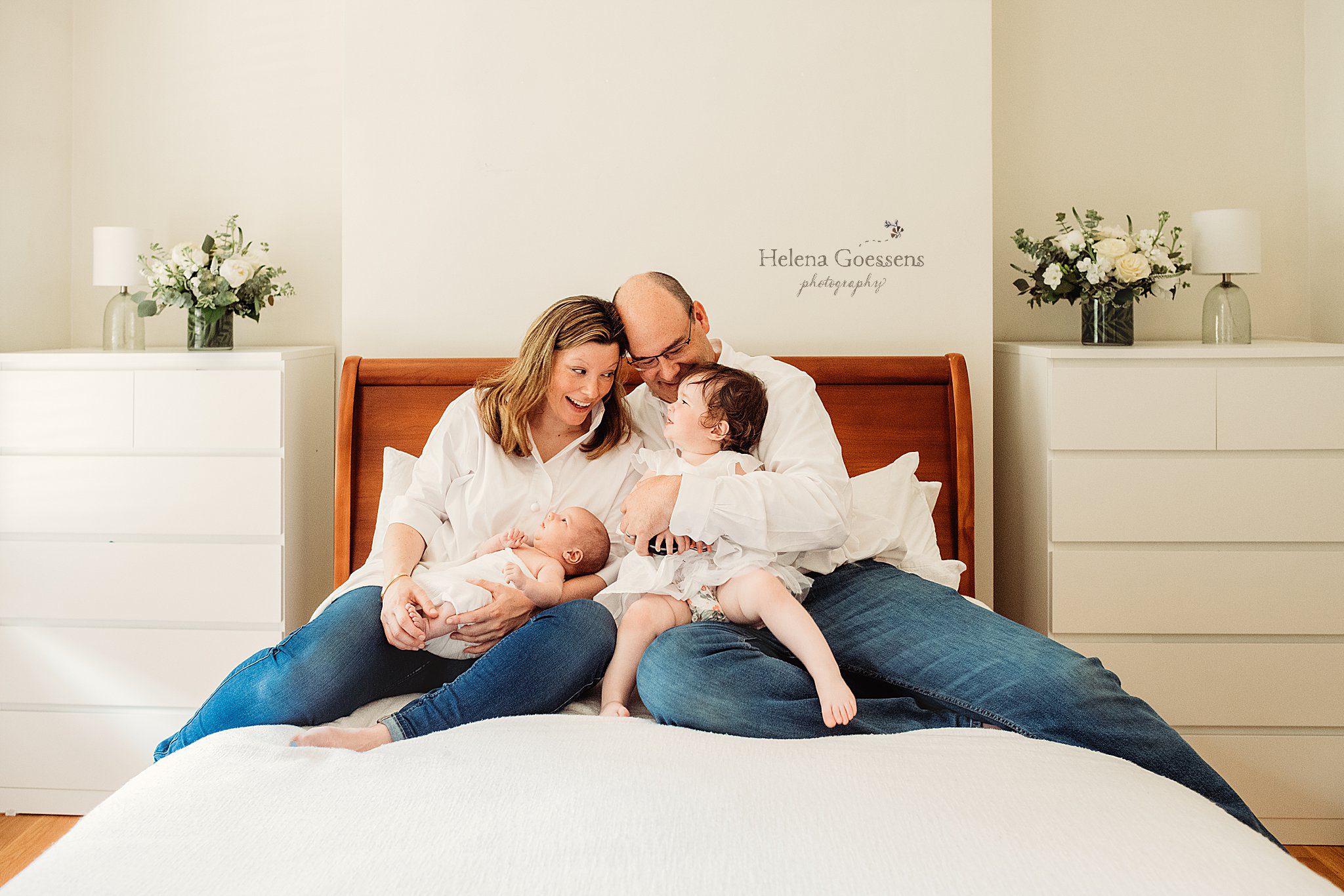 family of four sits on bed during South End newborn session at home 