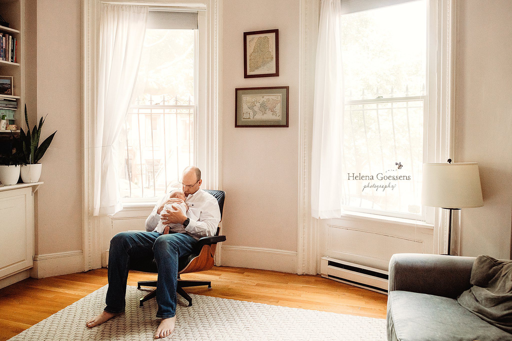 dad and son snuggle in living room during newborn portraits at home in Boston neighborhood 