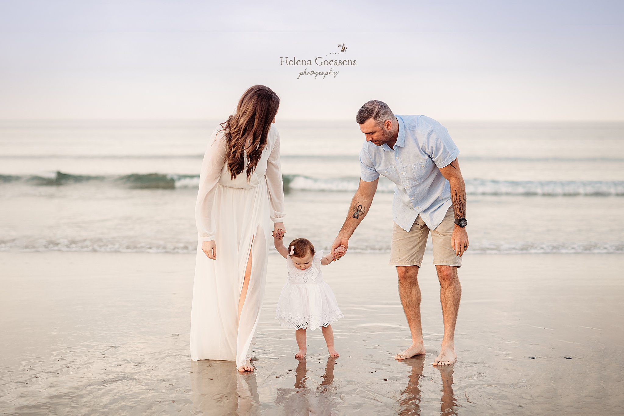 parents help toddler walk on sand during Rexhame Beach family session
