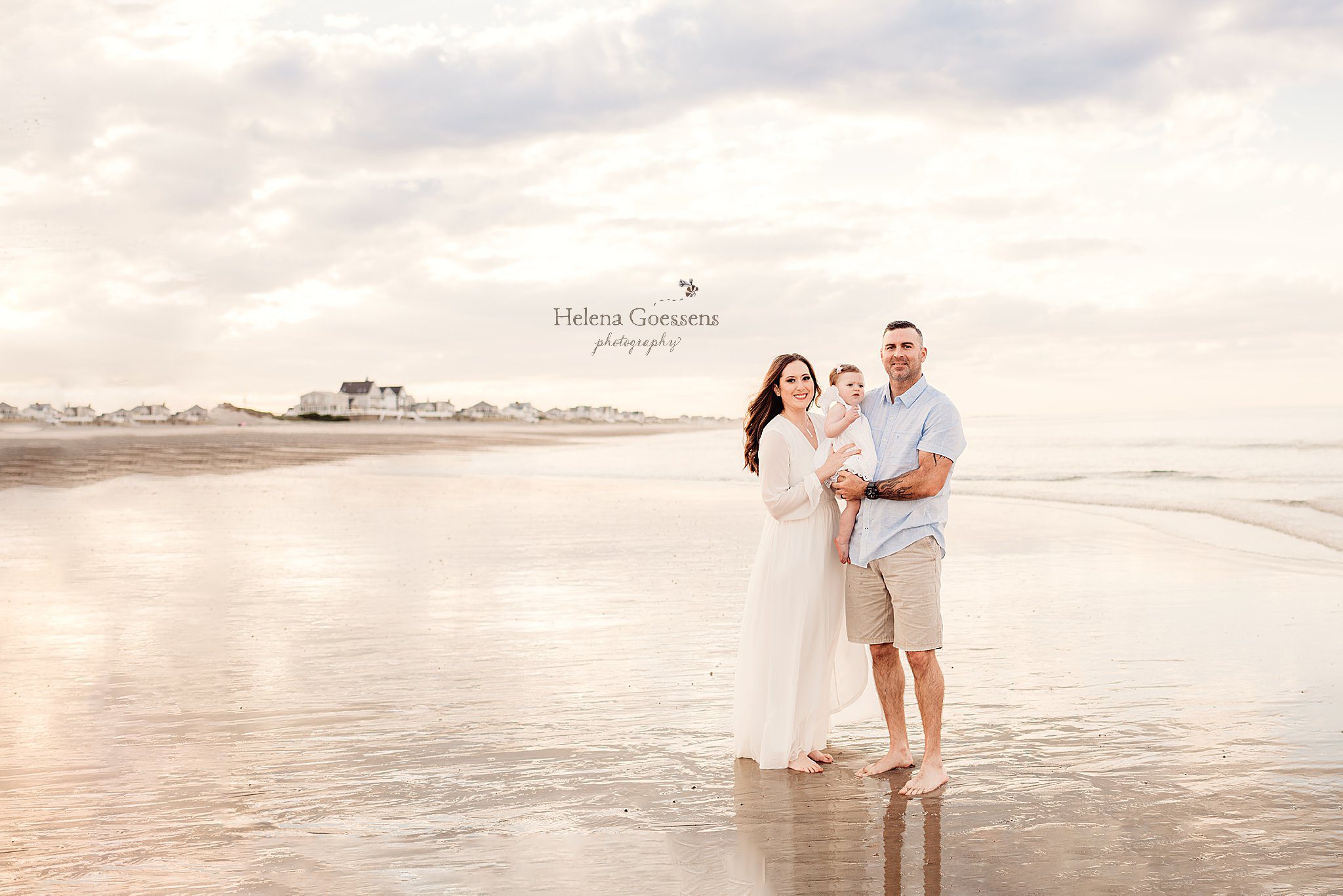 family of three stands in water during Rexhame Beach family session