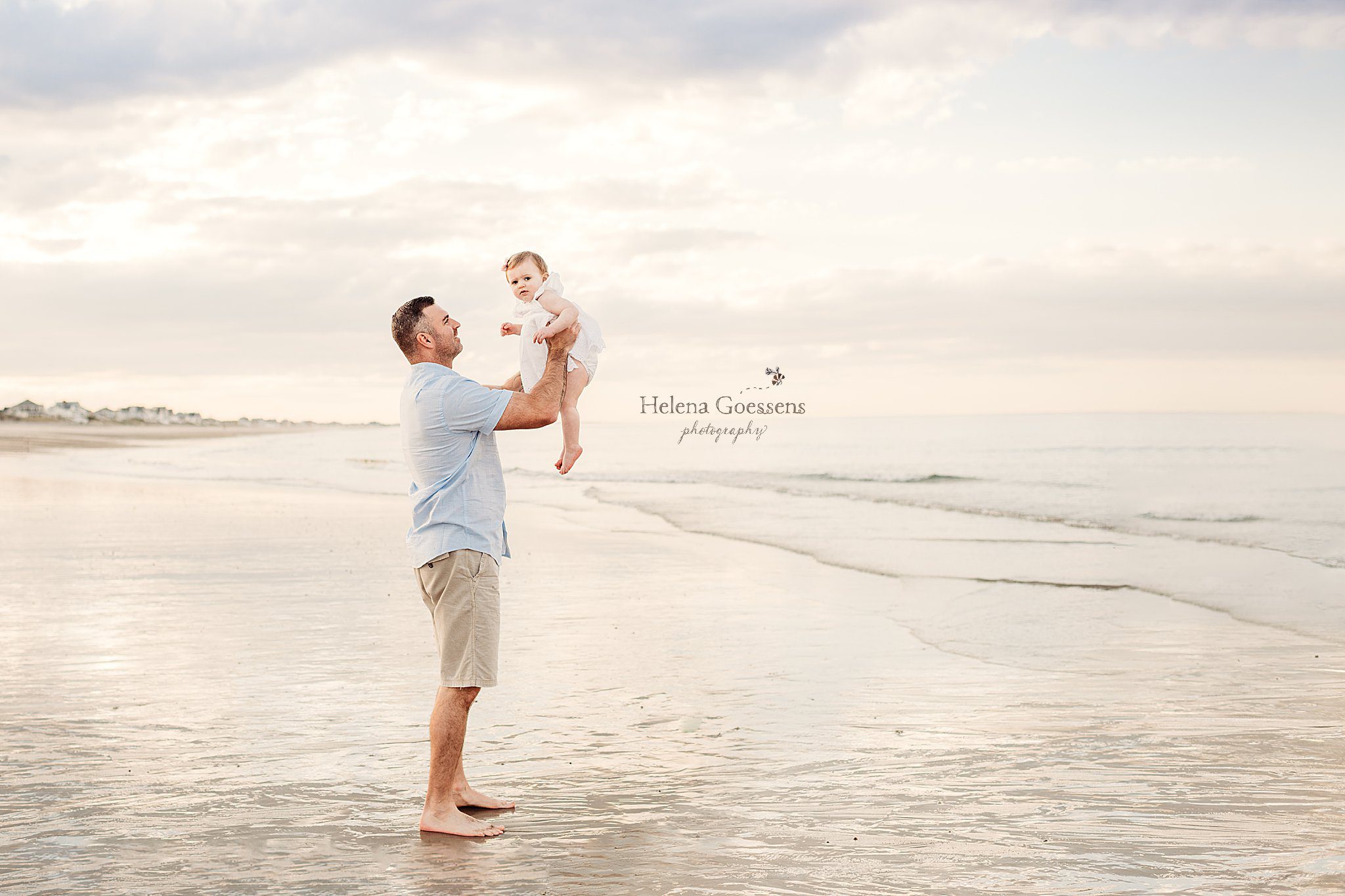 dad lifts girl up during family portraits on the beach in Massachusetts 