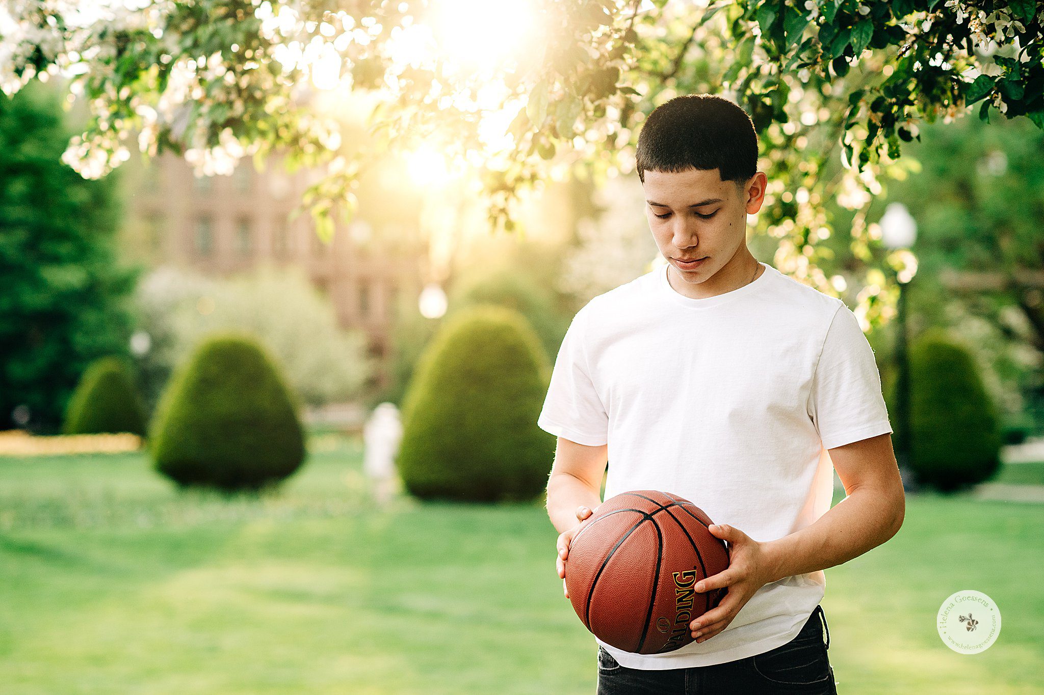 senior boy holds basketball in Boston Public Garden