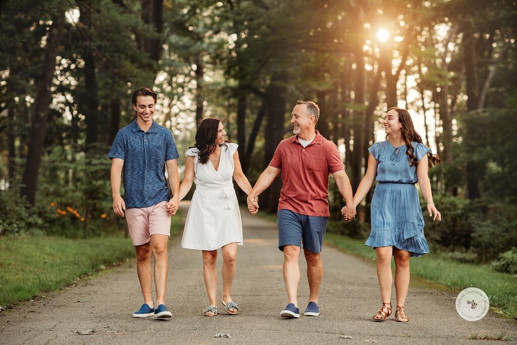 family of four holds hands walking at sunset during Bradley Estate Family Photos