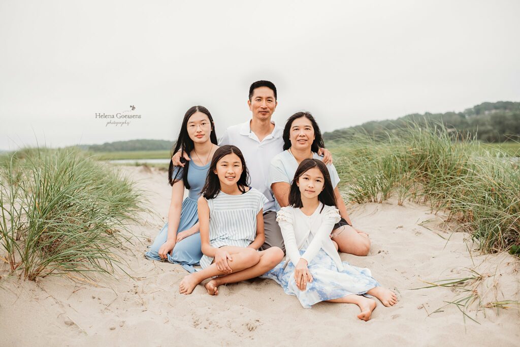 family sits on dunes during Extended Family Portraits at Rexhame Beach