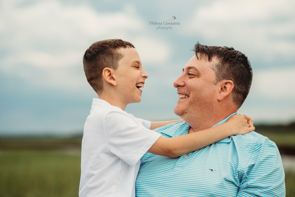 dad hugs son during MA family portraits on the beach 