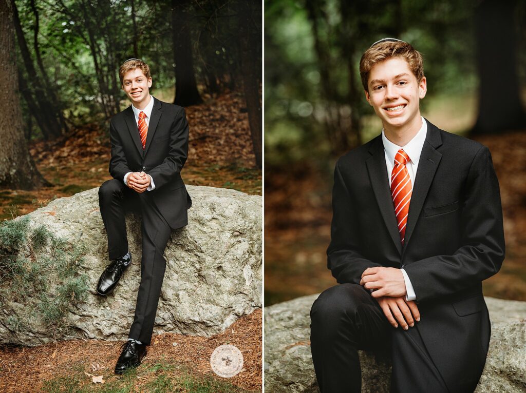 young man sits on rock with orange tie and suit before Bar Mitzvah at the Temple Beth Avodah