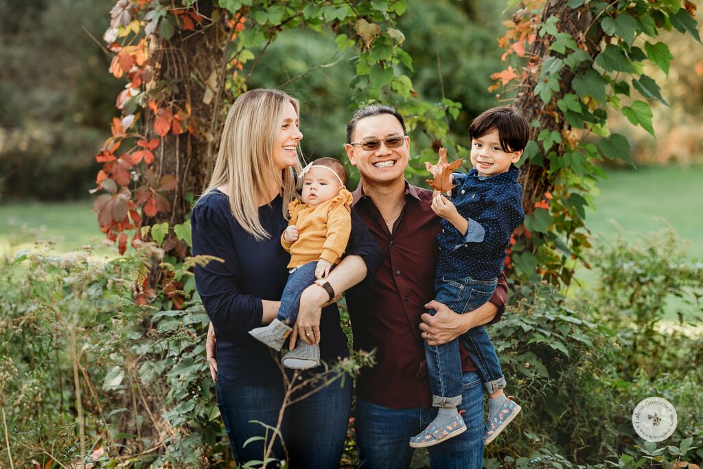 family of four poses during Fall Larz Anderson Park Family Photos
