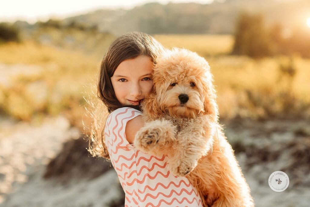 girl hugs new puppy during MA family photos on the beach 