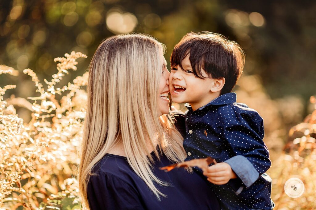 mom nuzzles son's cheek during fall Larz Anderson Park family photos