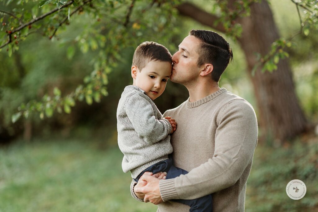 dad kisses son's forehead during fall portraits at the Bradley Estate