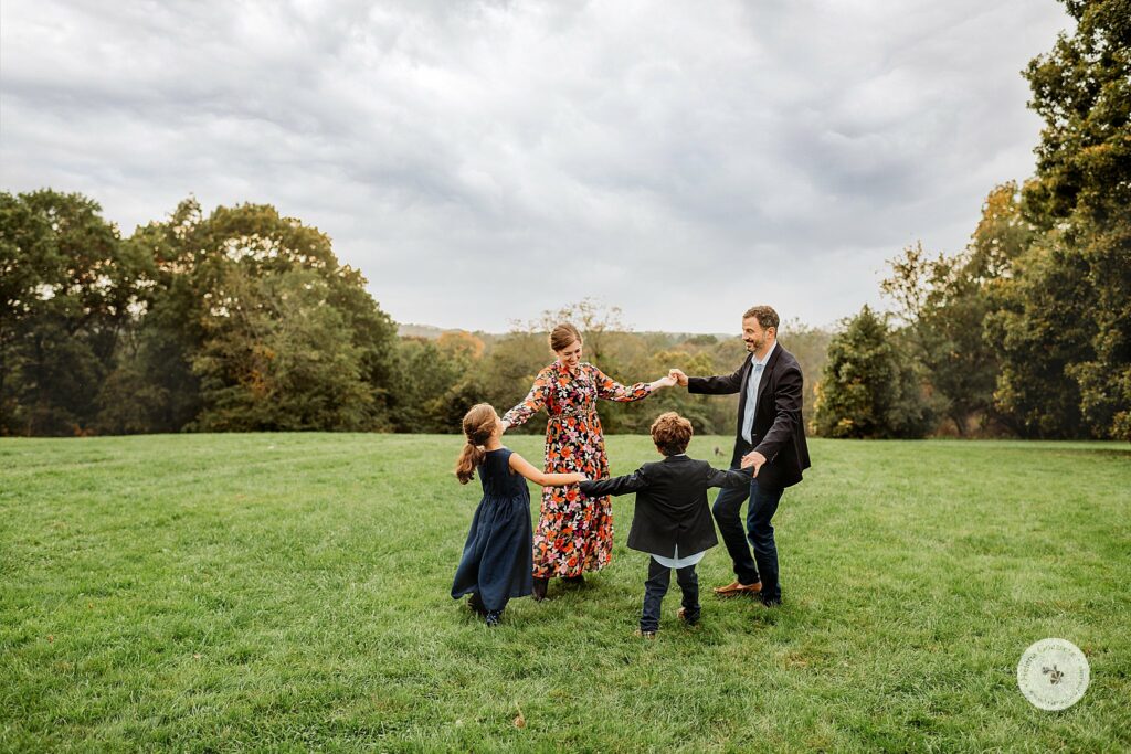 family of four plays together during Brookline MA Family Portraits at Larz Anderson Park 