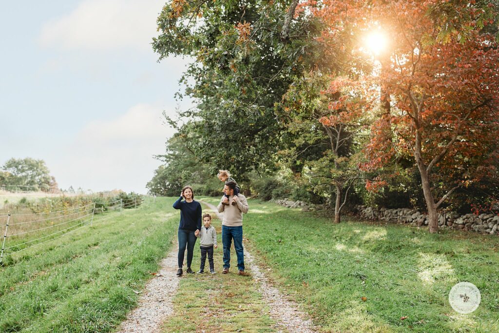 family walks together during fall portraits at the Bradley Estate
