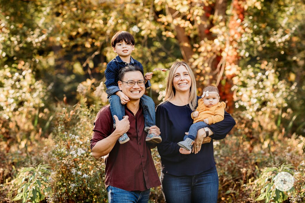 parents pose with two young children during fall Larz Anderson Park family photos