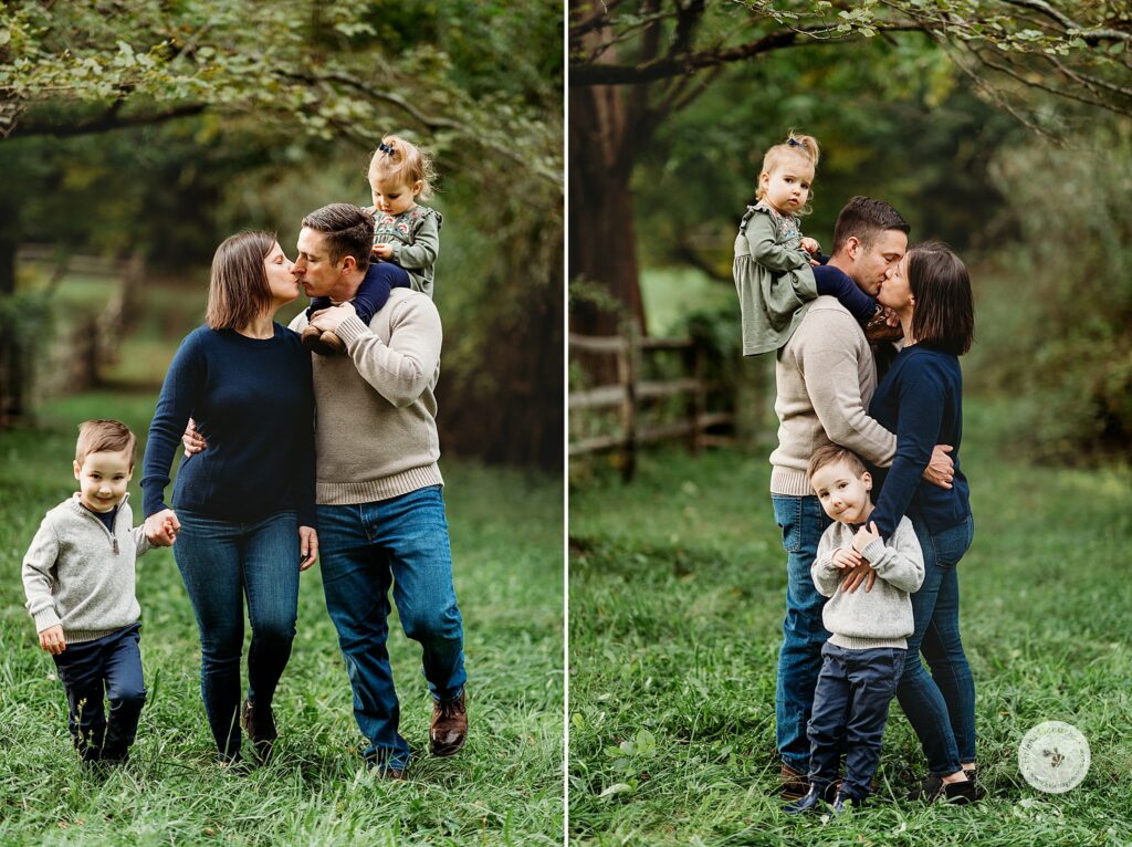 parents kiss while holding onto two young children during fall portraits at the Bradley Estate