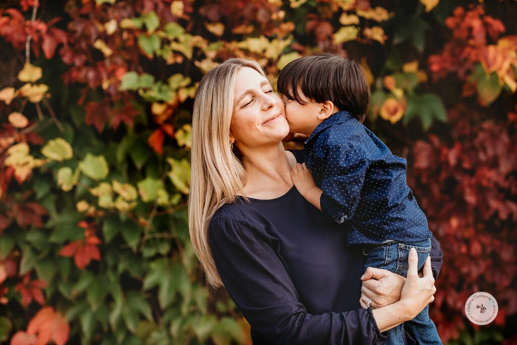 son kisses mom's cheek during MA family photos in the fall 