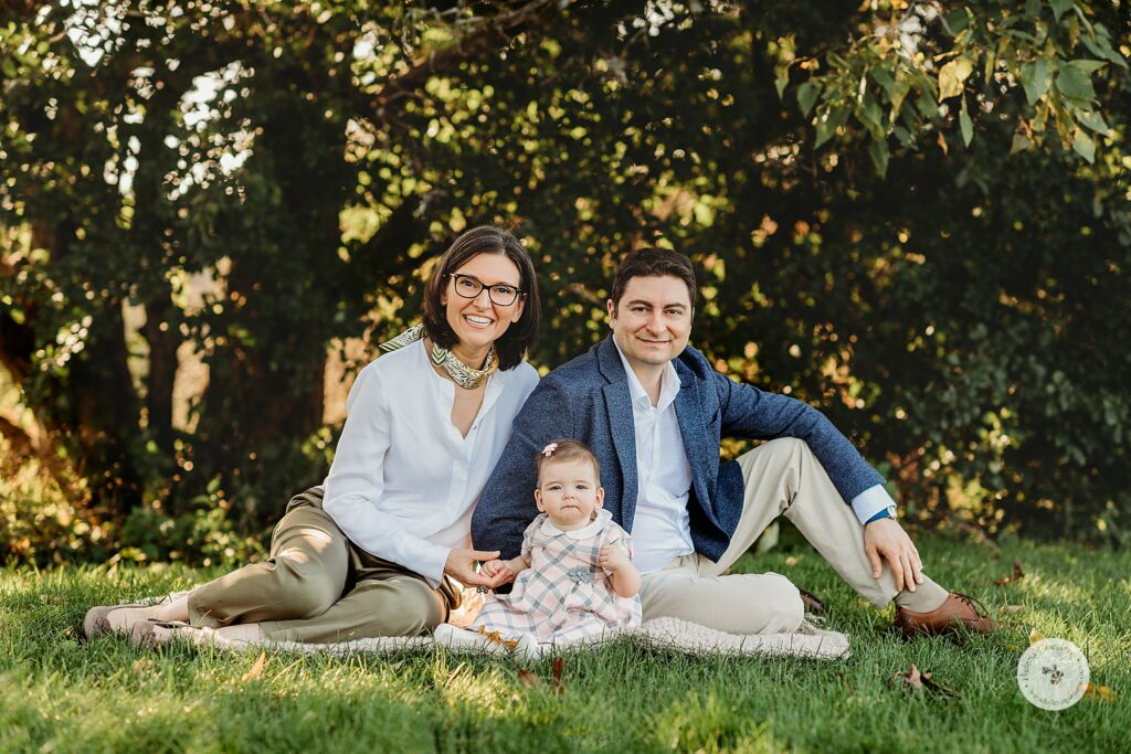 family sits in grass during fall Larz Anderson Park family portraits