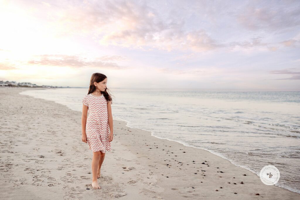 girl walks along water during sunset Rexhame Beach family photos