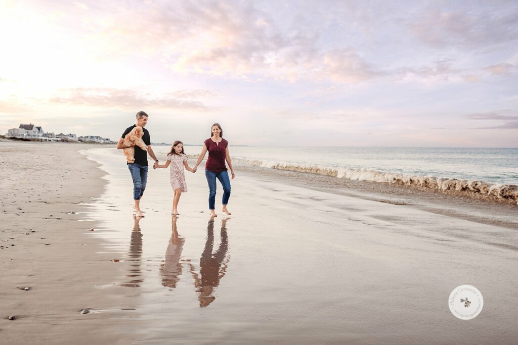 family of three walks on beach in Marshfield MA at sunset 