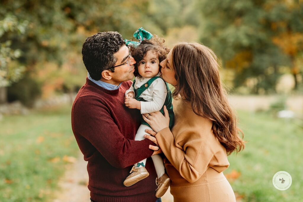 parents kiss toddler's cheeks during Fall Bradley Estate Family Portraits