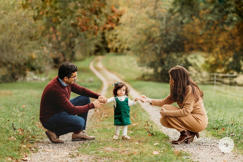 parents hold toddler up during fall family photos in Canton MA