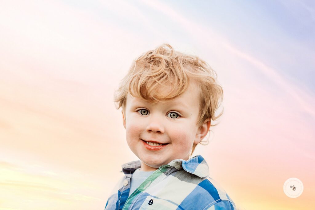toddler smiles at camera during Sunset Family Portraits at Larz Anderson Park