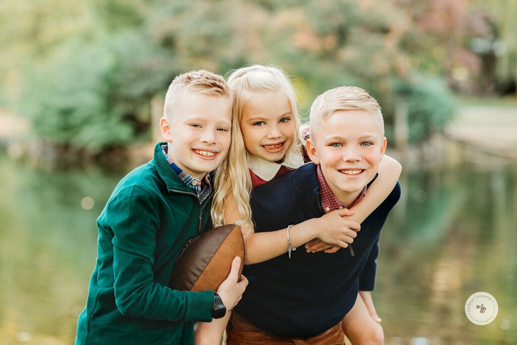 brothers hold up sister during Boston MA family photos 
