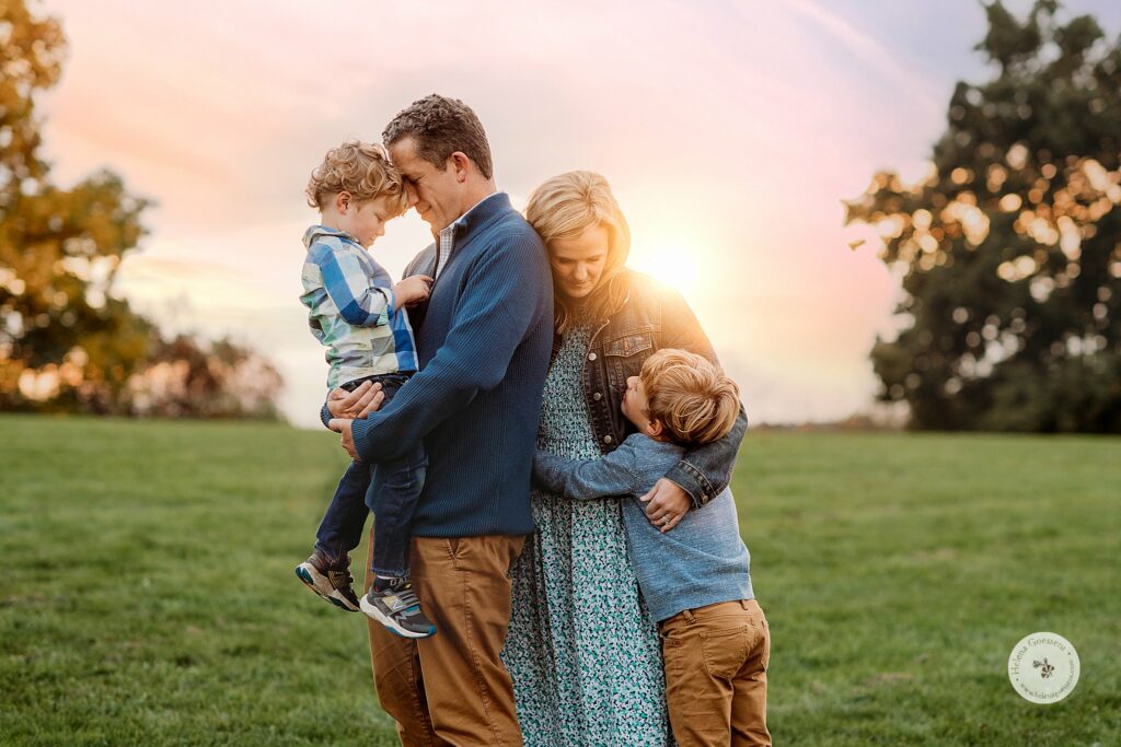 boys hug parents during sunset family photos in the fall 