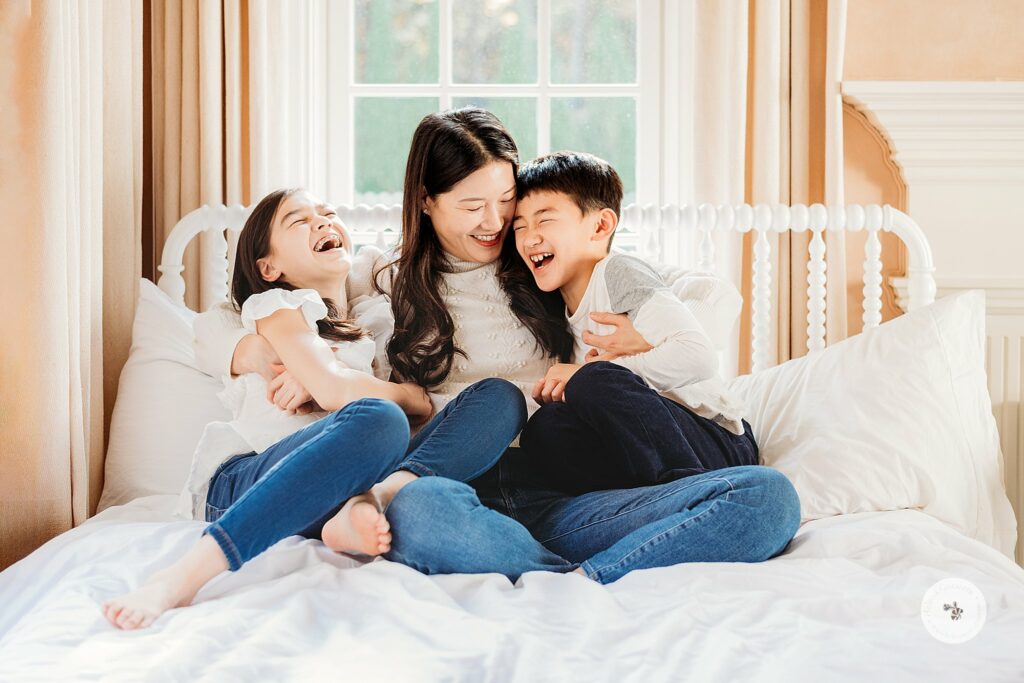 mom cuddles with two oldest kids during Weston MA Lifestyle Holiday Family Portraits