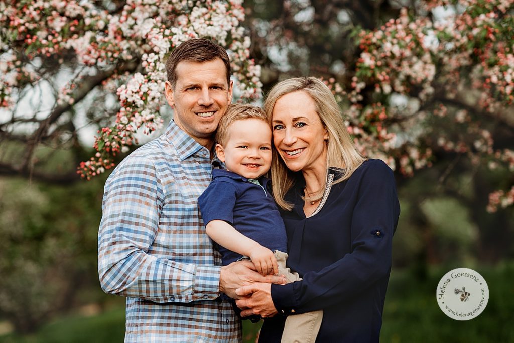 parents hold toddler in between them during spring family photos