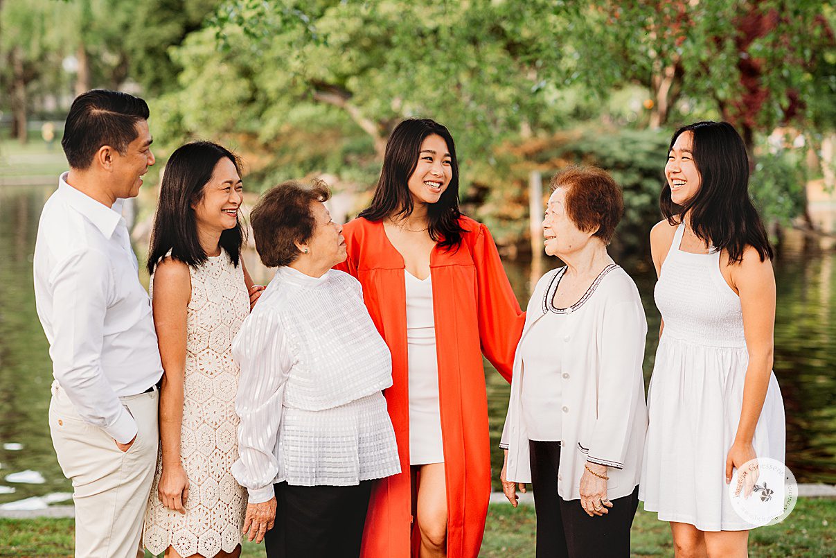 senior laughs with family during portraits in Boston Public Garden