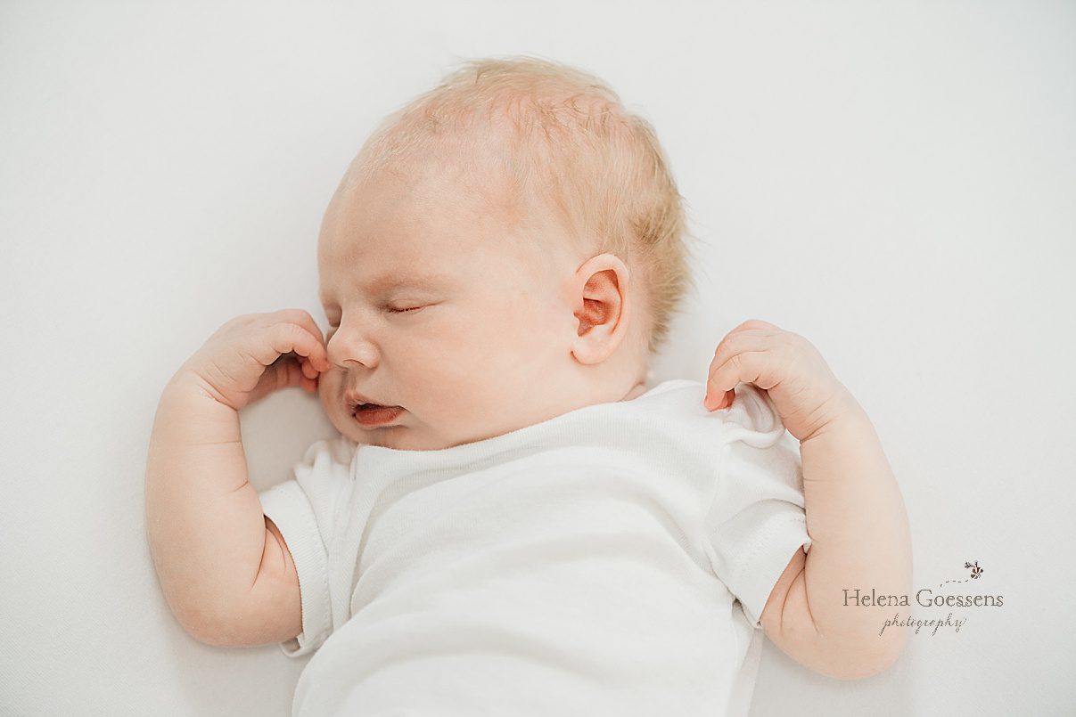 baby girl sleeps with arms curled up during lifestyle newborn portraits in Dedham MA