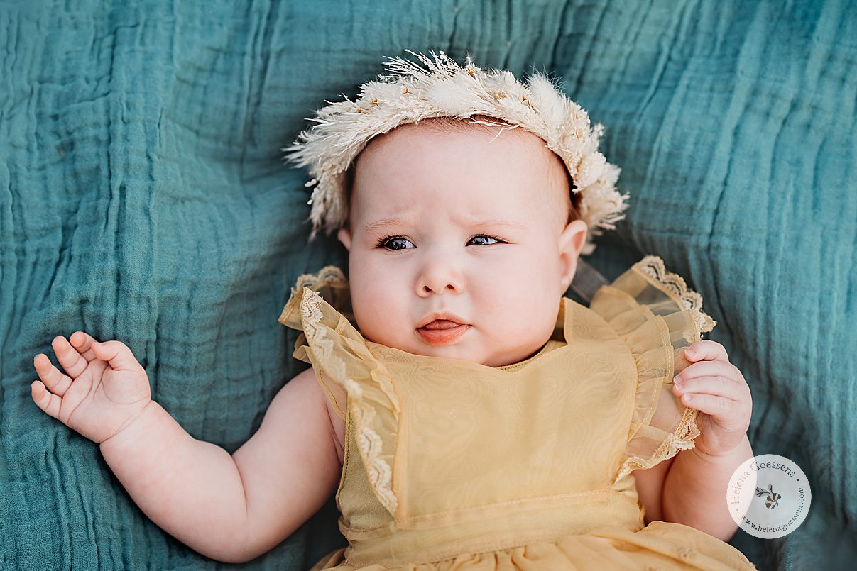 baby lays on teal blanket during Spring Family Portraits at Peter's Hill