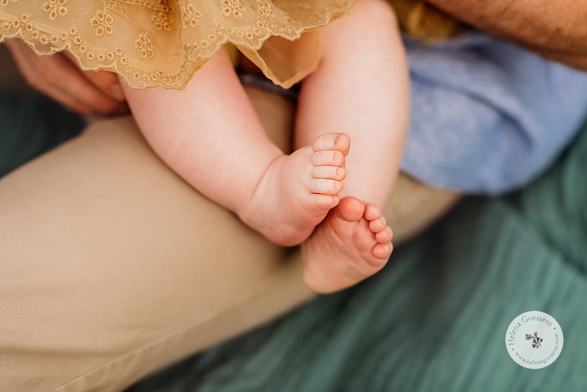baby rubs feet together during spring family photos in Boston MA