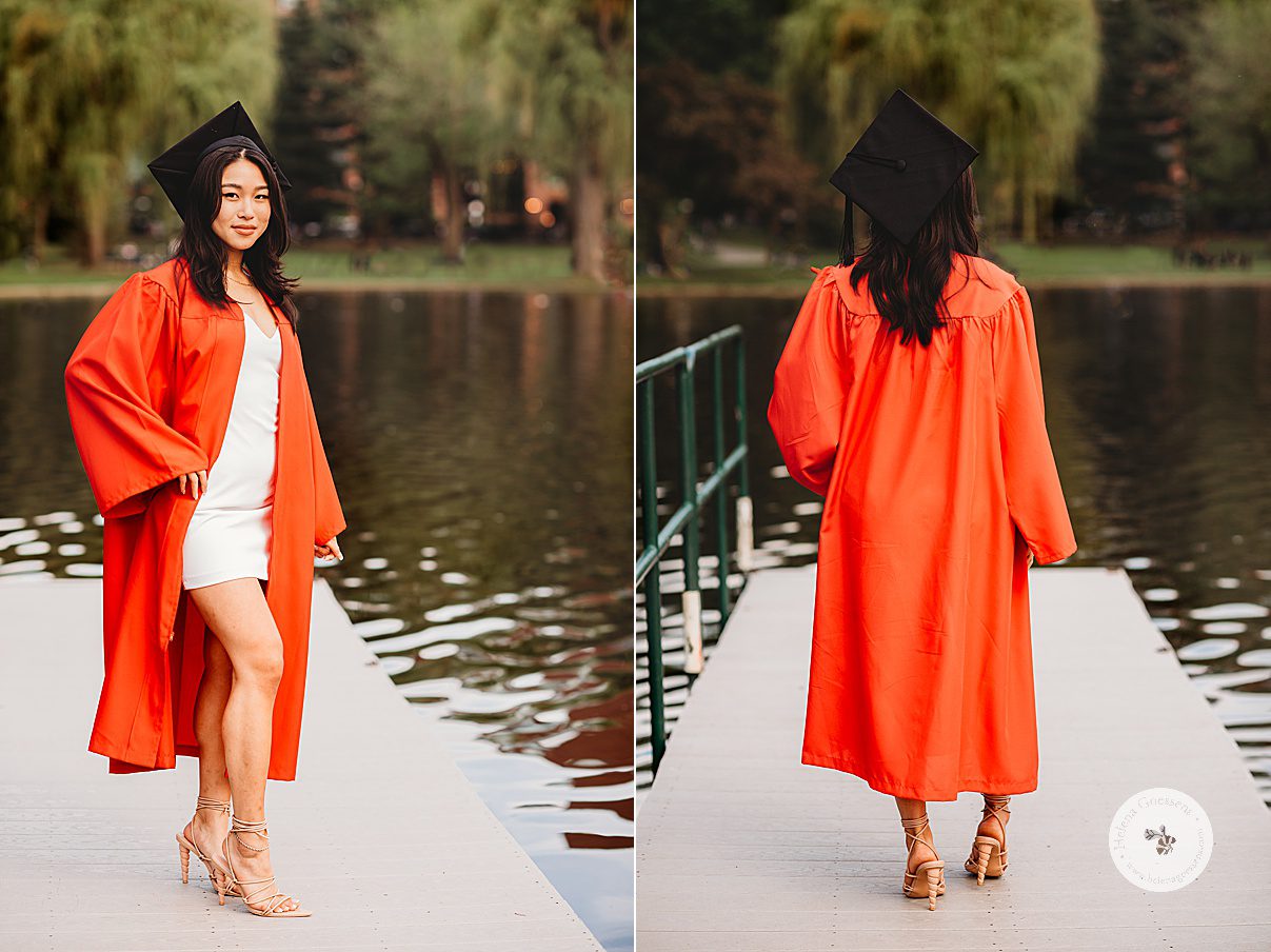 senior walks on pier during Boston University graduation portraits in red gown with black cap