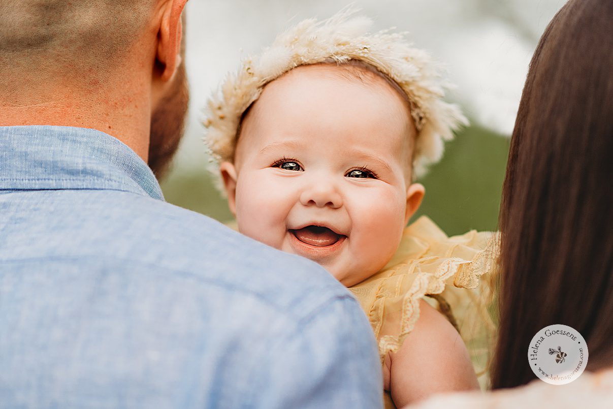 baby laughs over dad's shoulder during Spring Family Portraits at Peter's Hill