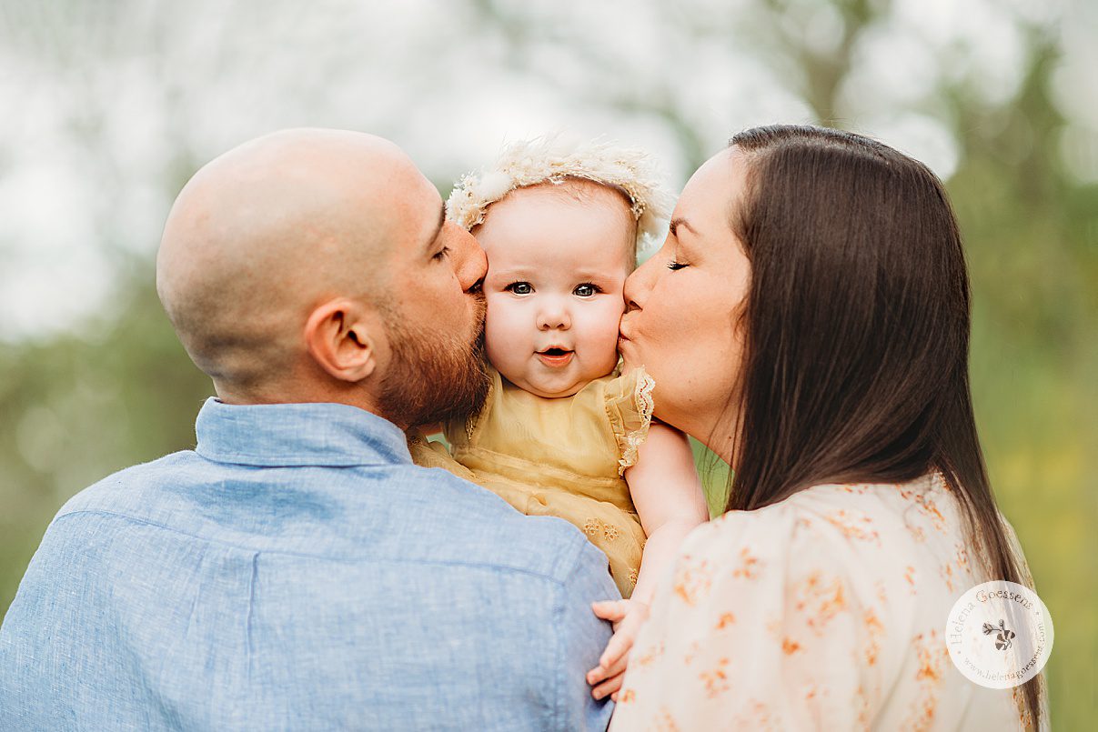 parents kiss baby girl's cheeks during Boston MA family photos with Helena Goessens 