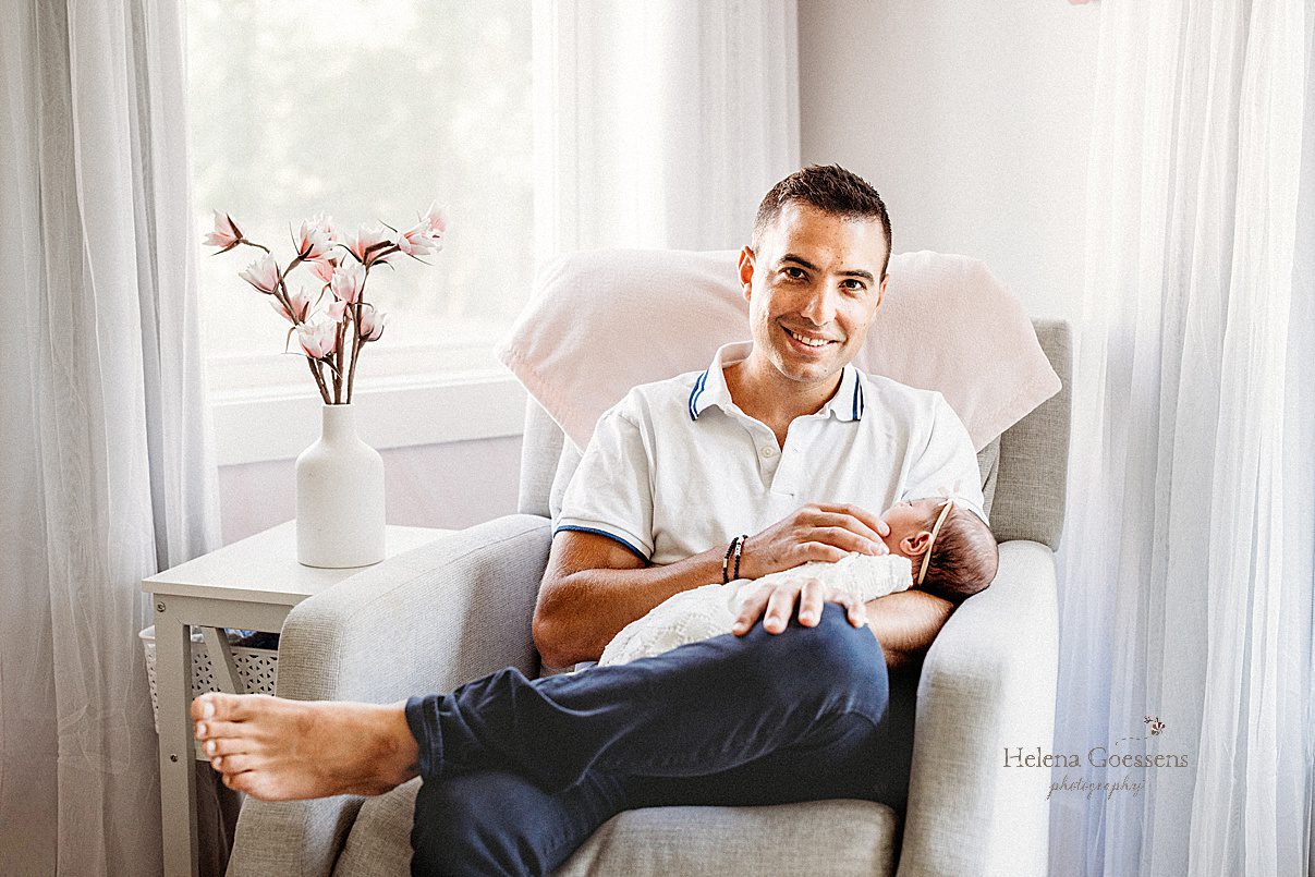 dad snuggles with daughter in corner chair during Newborn Session in Needham MA
