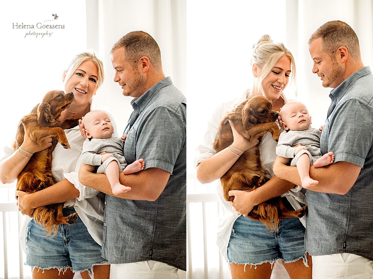parents hold newborn son and dog during MA family photos at home 