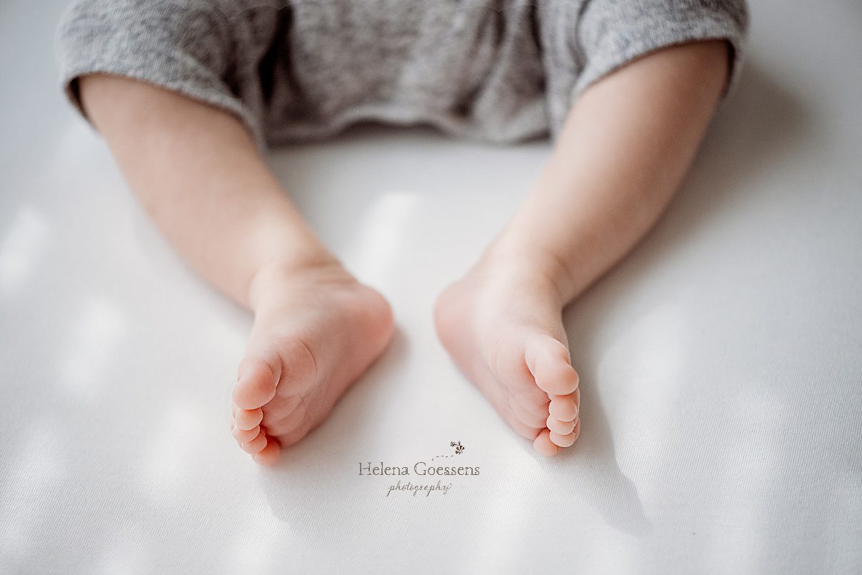boy's little legs on white sheets during newborn photos 