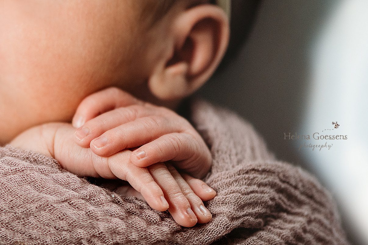 baby's little hands curled up under chin during Dedham MA lifestyle newborn portraits 